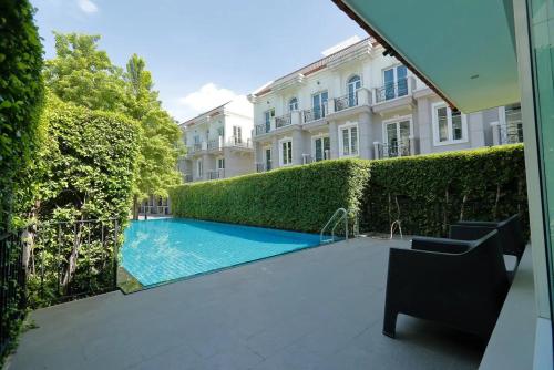 a swimming pool in front of a building at Sukhumvit 16 Townhouses, InHome Luxury Residences in Bangkok