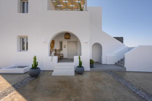 a white house with a staircase and potted plants at Marvarit Villas in Vóthon