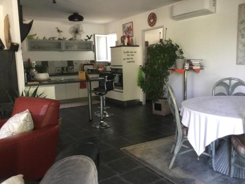 un salon avec une table et une cuisine dans l'établissement Rose, à Tonnay-Charente