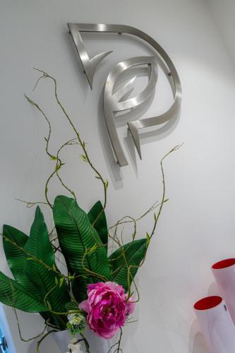a metal number hanging on a wall with a pink flower at Profumi di Primavera Luxury Rooms & Suite in Matera