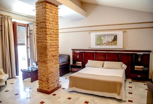 a bedroom with a bed and a brick pillar at Hotel Don Miguel Plaza in Berja