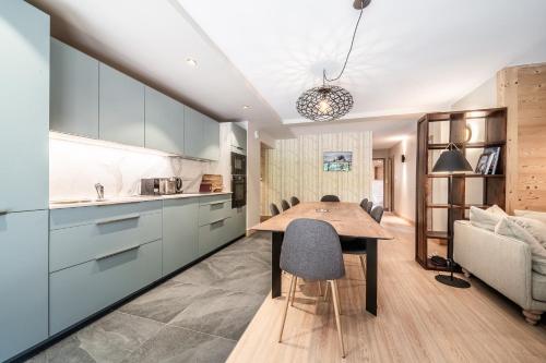 une cuisine et une salle à manger avec une table et des chaises en bois dans l'établissement CHALET PASCAL A101: 3 chambres + cabine neuf pour 8 personnes, à Morzine