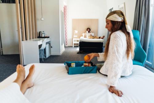 a little girl sitting on a bed in a hotel room at Stay Hotel Lisboa Centro Chiado in Lisbon