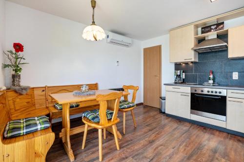 a kitchen with a wooden table and chairs in a room at Bungalow Sebastian in Lichtenwalde