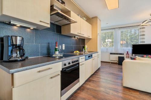 a kitchen with white cabinets and a counter top at Bungalow Sebastian in Lichtenwalde