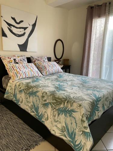 - un lit avec une couette colorée dans une chambre dans l'établissement Charmant T2 entièrement équipé avec terrasse, à Nanterre