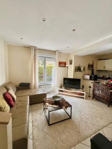 un salon avec un canapé et une table dans l'établissement Charmant T2 entièrement équipé avec terrasse, à Nanterre