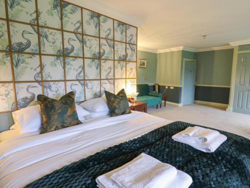 a bedroom with a large bed with towels on it at Llwynderw Hall in Llanwrtyd Wells