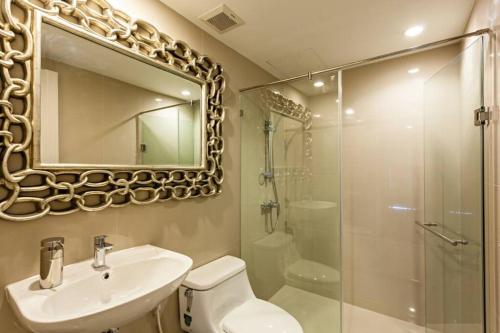 ein Badezimmer mit Toilette, Waschbecken und Dusche in der Unterkunft Sukhumvit 16 Townhouses, InHome Luxury Residences in Bangkok