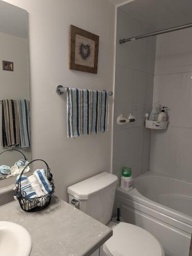 a white bathroom with a toilet and a sink at Bright Room full of love and warmth in Bowmanville