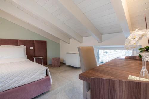a bedroom with a bed and a wooden table at Profumi di Primavera Luxury Rooms & Suite in Matera