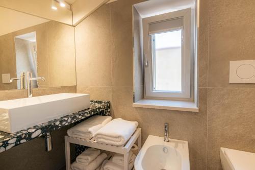 a bathroom with a sink and a toilet and a mirror at Profumi di Primavera Luxury Rooms & Suite in Matera