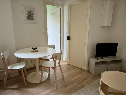 Cette petite chambre comprend une table, des chaises et une télévision. dans l'établissement Appartement Centre Paris, à Paris