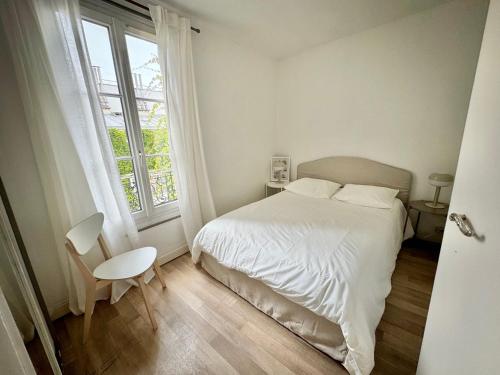 une chambre blanche avec un lit et une fenêtre dans l'établissement Appartement Centre Paris, à Paris