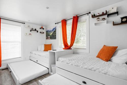 a bedroom with two beds and orange curtains at Sleeps 12, Indoor and Outdoor Theaters, Batting Cage, & Games! in Westfield