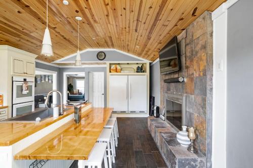a kitchen with wooden ceilings and a stone fireplace at Sleeps 10, Indoor and Outdoor Theaters, Batting Cage, & Games! in Westfield