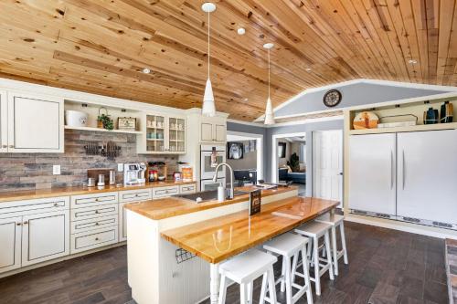 a kitchen with white cabinets and a wooden ceiling at Sleeps 10, Indoor and Outdoor Theaters, Batting Cage, & Games! in Westfield