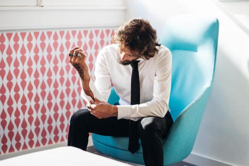 a man in a tie sitting in a chair at Stay Hotel Lisboa Centro Chiado in Lisbon