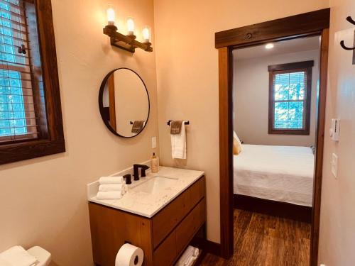 Un baño con lavabo, espejo y cama. en Elk Ridge Village 201A Cozy Cabin with views of Flathead Lake and the mountains, en Lakeside