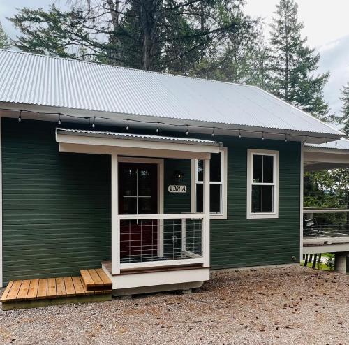 a green tiny house with a porch and a door at Elk Ridge Village 201A Cozy Cabin with views of Flathead Lake and the mountains in Lakeside