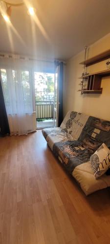 ein Schlafzimmer mit einem Bett in der Mitte eines Zimmers in der Unterkunft Apartament NELA in Krynica Morska