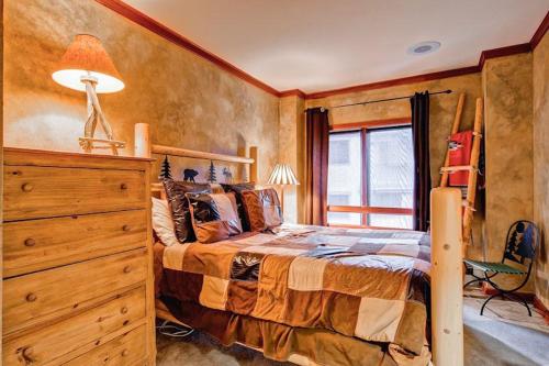 a bedroom with a bed and a dresser and a window at Village Hall 13 by East West Hospitality in Beaver Creek