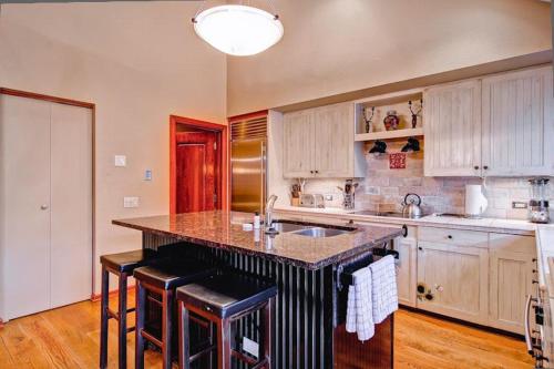 a kitchen with a large island with bar stools at Village Hall 13 by East West Hospitality in Beaver Creek