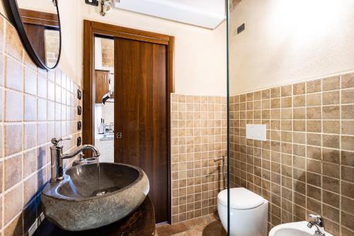 a bathroom with a stone sink and a toilet at La casa del Silenzio in Laiatico