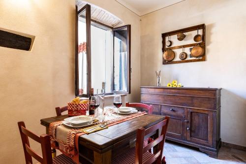 a dining room with a wooden table and a window at La casa del Silenzio in Laiatico