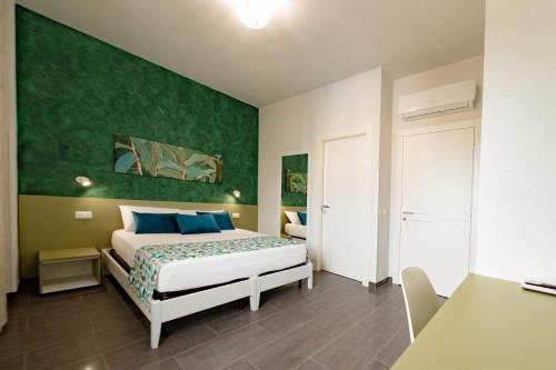 a bedroom with a bed and a green wall at Celeste Affittacamere in Cefalù