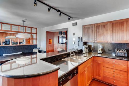 a kitchen with wooden cabinets and stainless steel appliances at Village Hall 12 by East West Hospitality in Beaver Creek