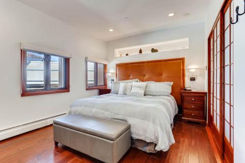 a bedroom with a large bed with a wooden headboard at Village Hall 12 by East West Hospitality in Beaver Creek