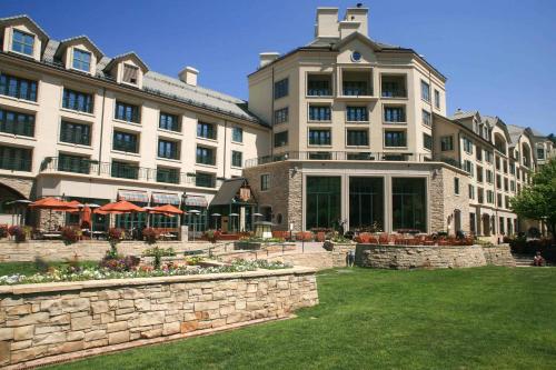 a large building with a stone wall in front of a yard at Village Hall 09 by East West Hospitality in Beaver Creek