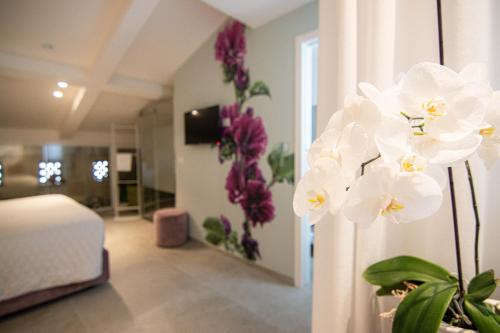 a room with a bed and purple and white flowers at Profumi di Primavera Luxury Rooms & Suite in Matera
