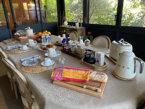 a table with a white table cloth with a tea set at Chambre d'hôtes - Petit ParadyZen - Lac du Salagou in Lacoste
