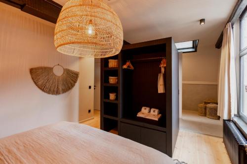 a room with a bed and a chandelier at BTFL Living Antwerp in Antwerp
