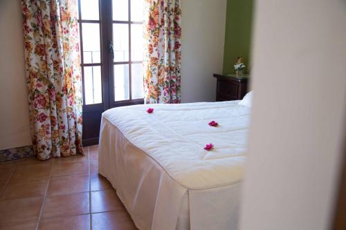 a bedroom with a bed with flowers on it at Hotel Rural Andalucia in Sierra de Yeguas