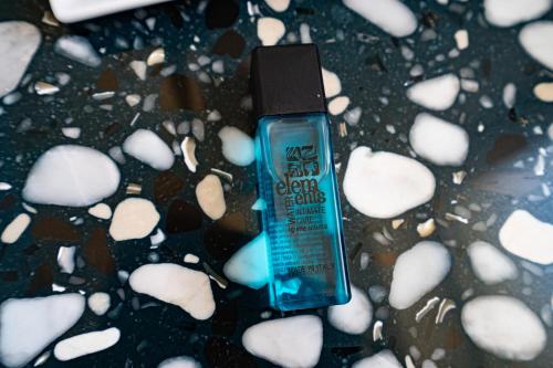 a bottle of hair lotion sitting on a table with rocks at Profumi di Primavera Luxury Rooms & Suite in Matera