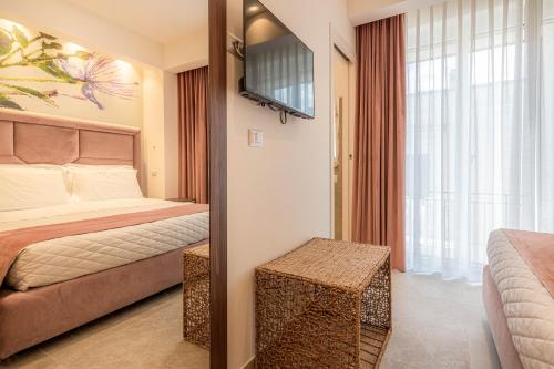 a hotel room with a bed and a television at Profumi di Primavera Luxury Rooms & Suite in Matera