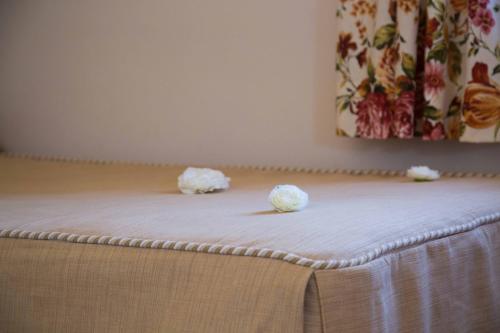 two white flowers sitting on top of a bed at Hotel Rural Andalucia in Sierra de Yeguas