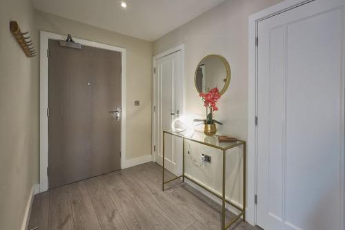 a hallway with a mirror and a dresser with a vase of flowers at Host & Stay - The Hideaway in York