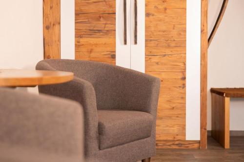a gray chair sitting next to a wooden table at Gasthaus Amboss in Ravensburg