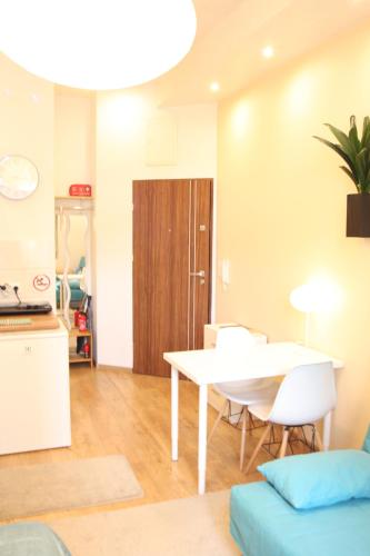 Una sala de estar con mesa y sillas y una cocina. en Blue Traveler AC Apartment in Kazimierz, en Cracovia