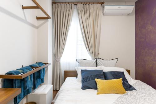 een slaapkamer met een bed met blauwe en gele kussens bij 4BR Luxury Pool Villa Siri Craft House Nimman in Chiang Mai