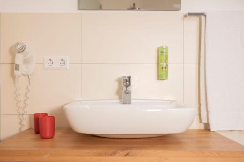 a white sink in a bathroom with a phone at Gasthaus Amboss in Ravensburg