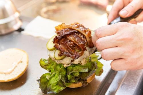 a person eating a sandwich with bacon and lettuce at Gasthaus Amboss in Ravensburg