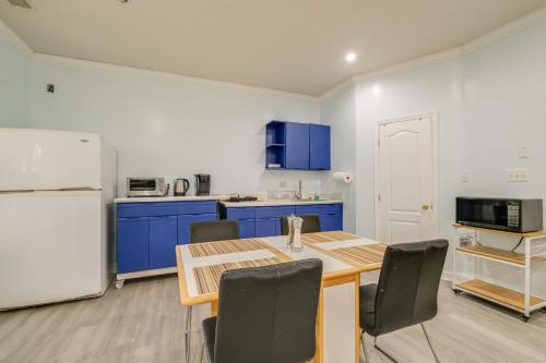 a kitchen with a table and blue cabinets and a refrigerator at Day Trip to DC - Sterling Studio with Pool Access in Sterling
