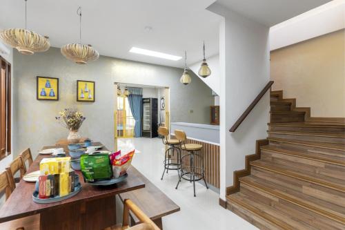 a kitchen and living room with a table and stairs at 4BR Luxury Pool Villa Siri Craft House Nimman in Chiang Mai