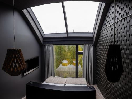 a room with a window with a bed in it at Hotel Ylläsrinne Deluxe in Ylläsjärvi