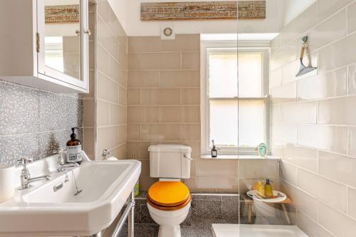 a white bathroom with a toilet and a sink at Spacious Country Cottage Sleeps 7 Near Bath Fire Pit Dog Friendly in Bradford on Avon